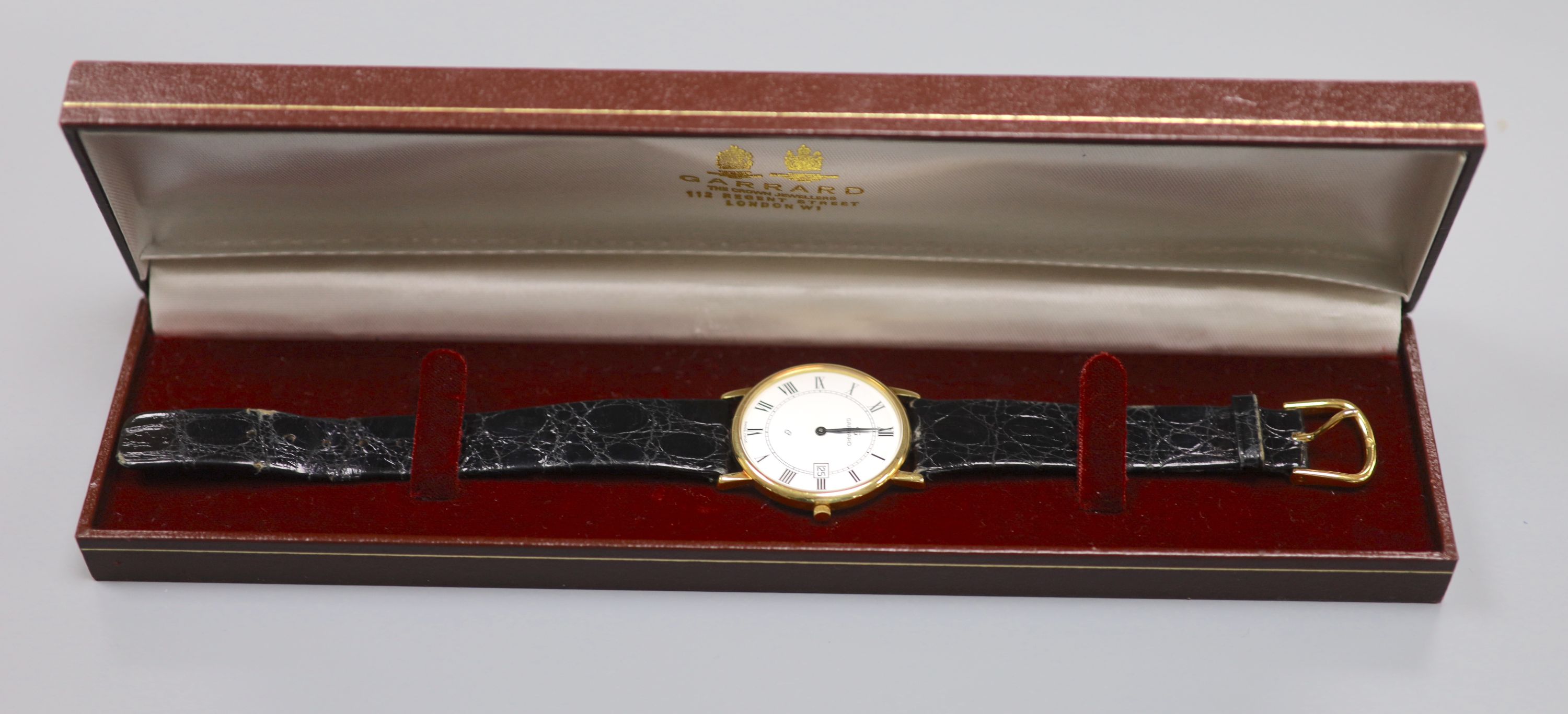 A gentlemans modern 18ct gold quartz dress wrist watch, retailed by Garrard, on a black leather strap, with Garrard box,